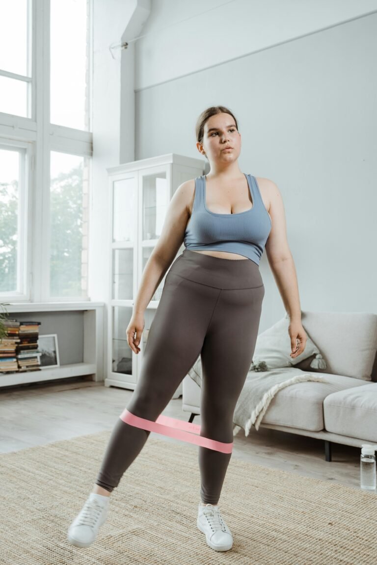 Curvy woman exercising with a resistance band at home, promoting body positivity and wellness.